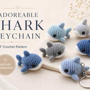 May include: A collection of five small, crocheted shark figures in shades of blue and gray, with one shark attached to a silver metal keychain. The text reads ADOREABLE SHARK KEYCHAIN, PDF Crochet Pattern, and INSTANT DOWNLOAD.
