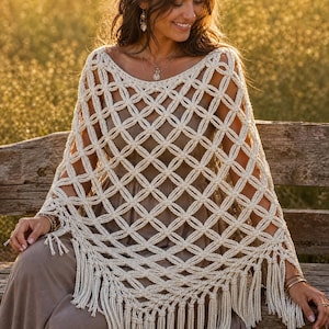 May include: An off-white, cream-colored crochet poncho featuring an openwork lattice pattern with circular motifs. The garment has a wide neckline and is finished with long, straight fringe tassels along the bottom hemline and side edges.
