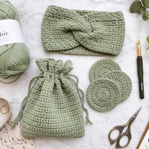 May include: A sage green crochet set including a skein of Dishie worsted weight 100% Pima cotton yarn, a twisted headband, a drawstring pouch, and three circular crochet pads. Also included are a 5.0mm crochet hook, a needle, and scissors.