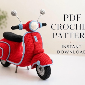 Pode incluir: Uma scooter de crochê vermelha com pneus pretos, assento preto e acabamento azul claro. A scooter possui dois espelhos prateados e um farol branco. O texto à direita diz PDF CROCHET PATTERN INSTANT DOWNLOAD em letras azul-escuras.