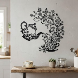 Puede incluir: Una pieza de arte mural de metal negro que muestra una tetera vertiendo un flujo de flores y mariposas en una taza de té. El diseño incluye patrones florales intrincados y múltiples siluetas de mariposas, creando una composición fluida.