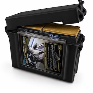 May include: A black plastic deck box with a hinged lid, featuring a clear front display window holding a Gonti, Nobile Archivist trading card. The interior contains two stacks of cards with gold-colored edges visible through the open top.