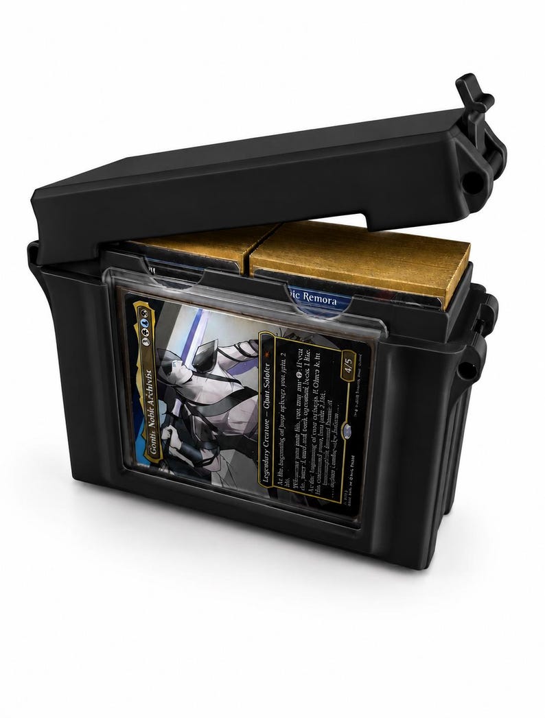 May include: A black plastic deck box with a hinged lid, featuring a clear front display window holding a Gonti, Nobile Archivist trading card. The interior contains two stacks of cards with gold-colored edges visible through the open top.