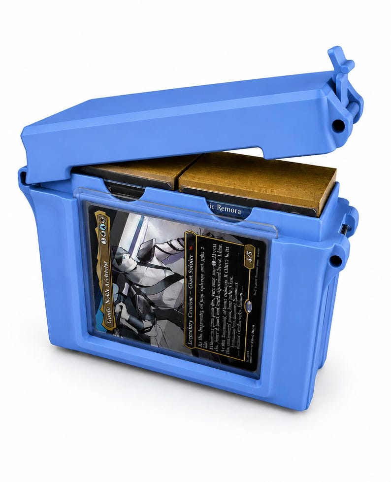 May include: A bright blue plastic deck box with a hinged lid, featuring a clear front display window holding a trading card titled Gonti, Noble Archivist. The interior contains two stacks of cards with gold-colored edges visible inside the container.