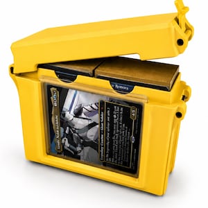 May include: A bright yellow plastic storage case for trading cards with a hinged lid. The front features a clear display window holding a single card with a black border and a character illustration. Inside, two stacks of cards are visible.