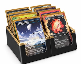 May include: A black and gold plastic card storage organizer holding multiple trading cards in protective sleeves. The front cards are clearly visible, displaying the text Hallowed Fountain and Sol Ring, along with their respective fantasy illustrations.