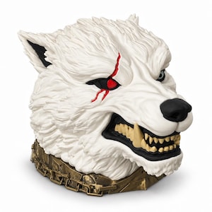 Peut inclure: Une figurine sculptée représentant une tête de loup blanc avec un pelage texturé, un museau noir et des crocs apparents. Une cicatrice rouge marquée s'étend depuis l'œil gauche. Le loup porte un collier en métal bronze vieilli à maillons.