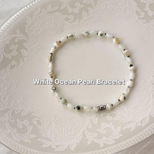 Pulsera de perlas y conchas hecha a mano, joyería de hematita inspirada en la playa natural.