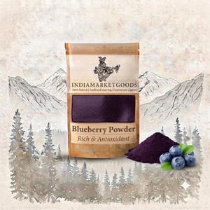 Op de afbeelding: Een beige zakje met het label IndiaMarketGoods Blueberry Powder Rich & Antioxidant met donkerpaars poeder zichtbaar door een doorzichtig venster. Naast het zakje ligt een hoopje donkerpaars poeder en enkele verse blauwe bessen.