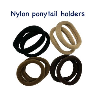 K&ouml;nnte beinhalten: Vier Haargummis aus Nylon in Schwarz, Beige, Braun und Dunkelbraun. Der Text "Nylon ponytail holders" ist oben im Bild in Blau dargestellt. Die Haaraccessoires sind quadratisch auf wei&szlig;em Hintergrund angeordnet.