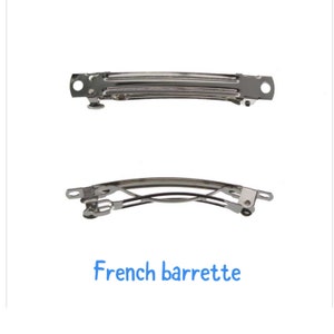 May include: Two silver French barrettes, one open and one closed. The barrettes are designed to hold hair in place.