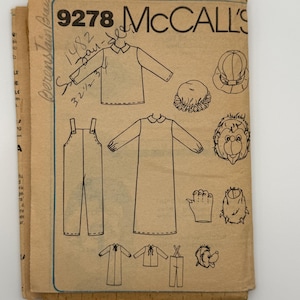 May include: A tan paper sewing pattern envelope labeled McCall's 9278 with black ink illustrations of overalls, a long-sleeved shirt, a nightgown, a hat, a mask, and gloves. Handwritten notes in black ink appear on the front of the envelope.