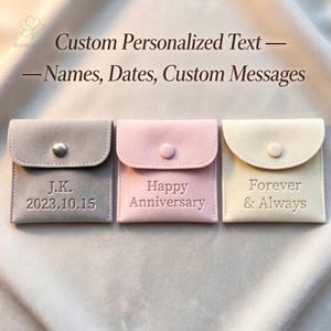 May include: Three square velvet pouches in gray, light pink, and cream, each featuring a snap button closure. The gray pouch is embossed with J.K. 2023.10.15, the pink with Happy Anniversary, and the cream with Forever & Always text.