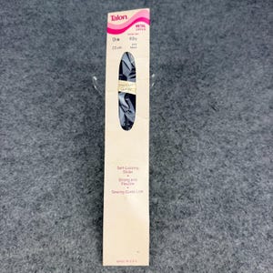 May include: A Talon brand navy blue metal zipper in its original packaging. The packaging is light beige with pink accents and text including 9 IN, 22 cm, Premium Quality, Self-Locking Slider, Strong and Flexible, and Sewing Guide Line.