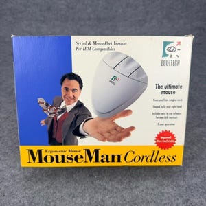 May include: A rectangular product box for a Logitech MouseMan Cordless ergonomic mouse. The box features a blue and white design with text including Serial & MousePort Version, The ultimate mouse, and MouseMan Cordless. A graphic shows a person in a suit holding the mouse.