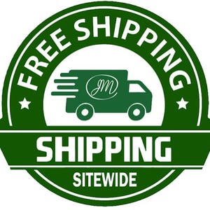 May include: A circular green and white emblem featuring a stylised delivery truck icon with the letters JM inside an oval. The text reads FREE SHIPPING in an arc at the top, SHIPPING in the centre, and SITEWIDE at the bottom with two stars.
