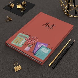 Peut inclure: Un carnet à couverture rigide de couleur terre cuite avec le mot "Math" imprimé en écriture noire. La couverture présente une illustration graphique d'une calculatrice, d'un rapporteur, d'un pot à crayons et de deux petits carnets "Science" et "Math".