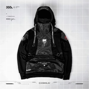 May include: A black hooded sweatshirt featuring a high neck collar, long sleeves, and a large front pocket. The garment includes white graphic text reading HAYABUSA, adjustable straps, and various technical design elements in white and red.