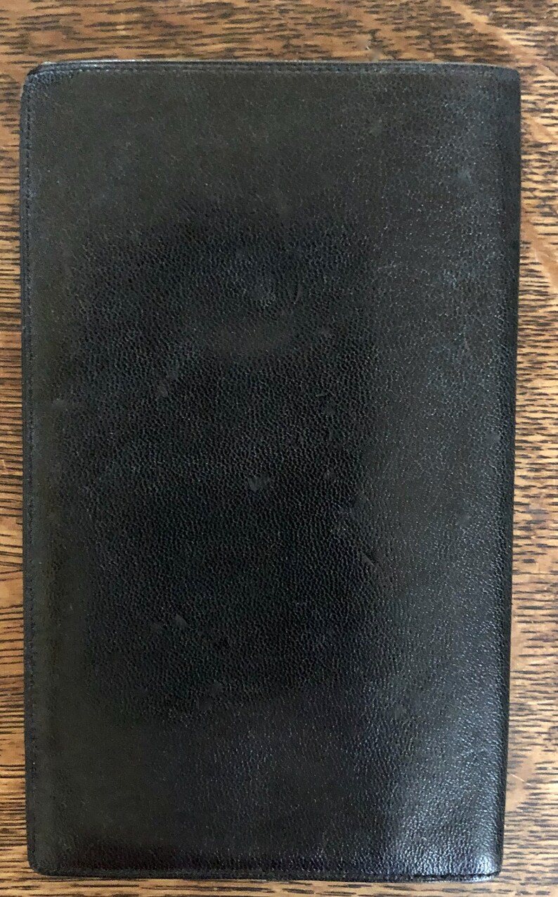 May include: A black leather wallet with a textured surface.