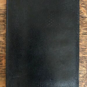 May include: A black leather-bound journal with a textured cover.