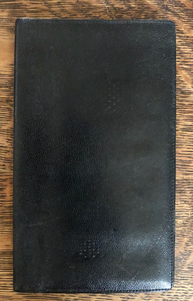May include: A black leather-bound journal with a textured cover.