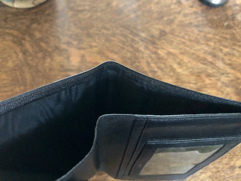 May include: Black leather wallet with a clear plastic window for identification.