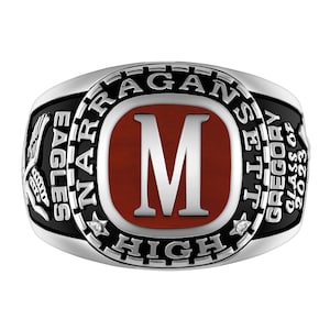 Puede incluir: Un anillo de graduación plateado con una incrustación ovalada roja central y una letra M plateada. El borde negro está grabado con NARRAGANSETT HIGH, dos estrellas pequeñas, EAGLES, GREGORY y CLASS OF 2023 en letras plateadas sobre fondo negro.