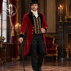 Op de afbeelding: Een rode fluwelen pandjesjas met zwarte fluwelen revers en manchetten met gouden borduursels, gedragen over een zwart vest met gouden gevlochten sluitingen en knopen. De outfit bevat een witte cravat, een zwarte broek en een zwarte hoge hoed.