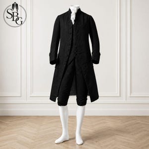 Puede incluir: Un conjunto negro de estilo histórico que incluye una casaca de manga larga con calzones a juego hasta la rodilla y un chaleco. El atuendo presenta una corbata blanca en el cuello y botones forrados de tela en la parte frontal de la casaca.