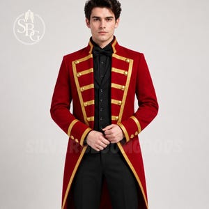 May include: A red tailcoat jacket featuring gold trim and gold buttons, worn over a black button-down shirt and black trousers. The jacket has a high collar and long sleeves with gold cuffs. A circular logo with the letters SPG is visible.