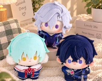 May include: Three plush dolls with stylized hair and embroidered facial features. One doll has light blue hair and a white-trimmed outfit, one has lavender hair in a dark blue suit, and one has dark blue hair in a patterned navy outfit.