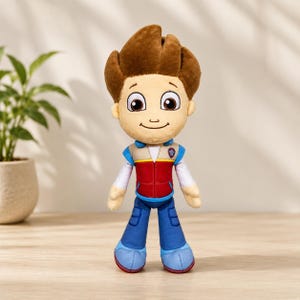 Könnte beinhalten: Ein Plüschtier einer Zeichentrickfigur mit braunen Haaren, großen Augen und einem lächelnden Gesichtsausdruck. Die Figur trägt eine rote und beige Weste über einem weißen langärmeligen Hemd, eine blaue Hose und hellblaue Schuhe.
