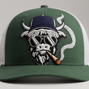 Puede incluir: Una gorra de camionero verde y blanca con un parche bordado de una vaca Highland que lleva una gorra de béisbol azul oscuro y gafas de sol, con un cigarrillo encendido en la boca y una estela de humo blanco saliendo del cigarrillo.