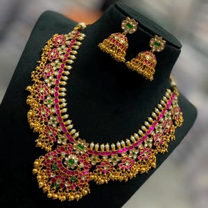 Conjunto de collar Jadau Kundan chapado en oro con gargantilla nupcial de rubíes, esmeraldas y perlas.