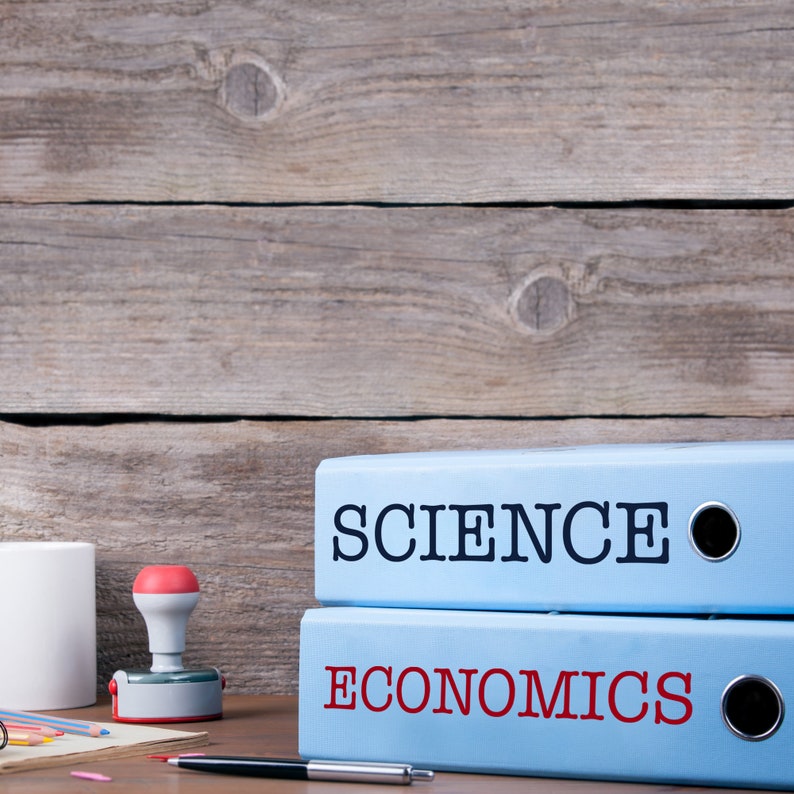 K&ouml;nnte beinhalten: Zwei blaue Ordner mit wei&szlig;en Etiketten. Der obere Ordner tr&auml;gt die Aufschrift "SCIENCE" in schwarzer Schrift. Der untere Ordner tr&auml;gt die Aufschrift "ECONOMICS" in roter Schrift.