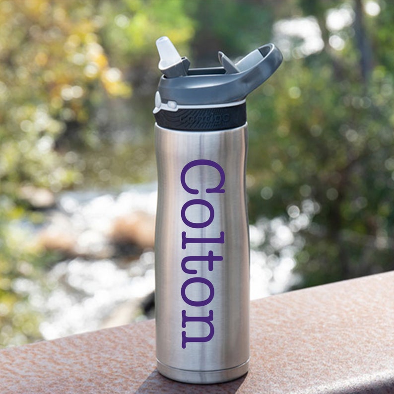 May include: A silver water bottle with a black lid and a purple name "Colton" on the side.