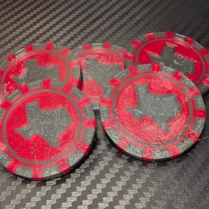 Puede incluir: Un conjunto de cuatro fichas de póquer circulares con un esquema de color rojo y gris. Cada ficha muestra una silueta gris en relieve del estado de Texas centrada en un campo circular rojo, rodeada por un borde gris con muescas rectangulares.
