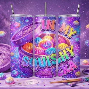 May include: A purple galaxy-themed tumbler with a straw featuring a bamboo steamer basket graphic filled with colourful dumplings and the text "IN MY SQUISHY ERA" in a bold, gradient font. The design includes scattered sparkles and small dumpling icons.