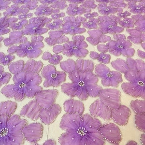 May include: Purple floral lace fabric with 3D flowers and pearl embellishments.
