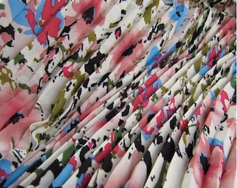 May include: White fabric with a pleated texture and a floral print in shades of pink, blue, and black.