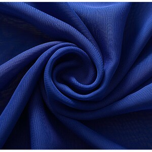 Puede incluir: Primer plano de una tela azul real con una textura suave y fluida. La tela est&aacute; doblada y drapeada, mostrando su ca&iacute;da y brillo. El texto "29#  宝蓝" es visible en la esquina superior izquierda de la imagen.