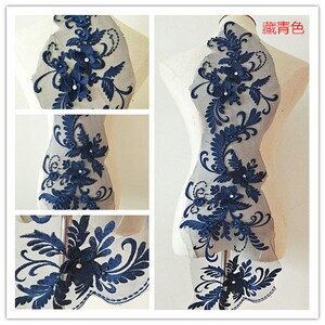May include: Navy blue floral lace applique with beaded embellishments. The lace is on a sheer mesh background. The applique is ideal for adding a touch of elegance to any garment or project.