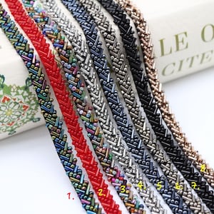 May include: Eight different beaded trims with a chevron pattern. The trims are in various colors, including black, silver, red, and multi-colored.