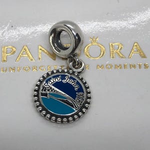 Può includere: Un charm in argento con un pendente circolare dal bordo perlato. Il centro presenta un design in smalto blu e turchese raffigurante un ponte con la scritta Saint John NB. Il charm ha un occhiello in argento lucido per il bracciale.