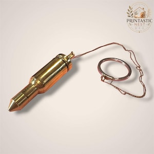 May include: A polished brass plumb bob with a pointed tip and a cylindrical body, attached to a thin metallic chain that connects to a circular metal ring. The object features a smooth, reflective surface and a distinct, tapered conical end.