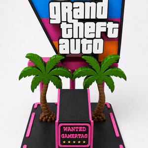 Pode incluir: Um expositor 3D com o logótipo Grand Theft Auto V em azul, rosa e laranja. Duas palmeiras verdes com troncos castanhos sobre uma base preta. Um pilar central preto apresenta o texto WANTED GAMERTAG em rosa com cinco estrelas amarelas.