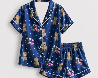 Colección de pijamas de satén azul marino con motivos de ositos de peluche y trenes.