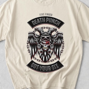 May include: A cream-colored short-sleeve t-shirt featuring a graphic of a winged skull wearing goggles and holding wrenches. The text reads FIVE FINGER DEATH PUNCH and GOT YOUR SIX, framed by a chain border in black, white, and red ink colors.