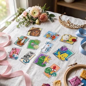 May include: A collection of twelve rectangular embroidered patches featuring various animated characters, including a tiger, a dragon, a raccoon, a chameleon, a snowman, a fish, a chicken, and a teacup, arranged on a white fabric surface.