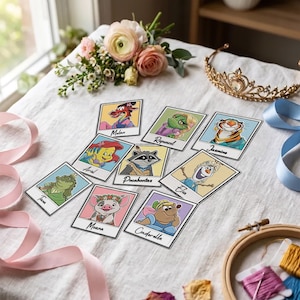 May include: A collection of nine square cards featuring cartoon animal sidekicks with names printed below each: Mulan, Rapunzel, Jasmine, Ariel, Pocahontas, Elsa, Tiana, Moana, and Cinderella. The cards are arranged on a white fabric surface.